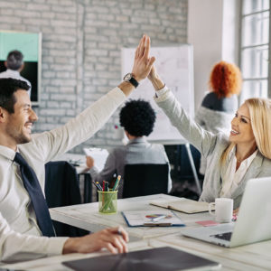 Happy business people supporting each other and giving high five in the office.